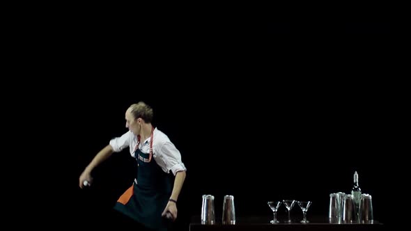 Bartender Juggling the Objects on Black Background