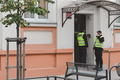 Two policemen are standing in front of the building's entrance door - PhotoDune Item for Sale