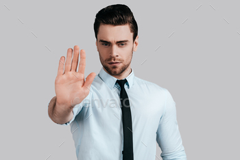 turing and looking at camera while standing against grey background