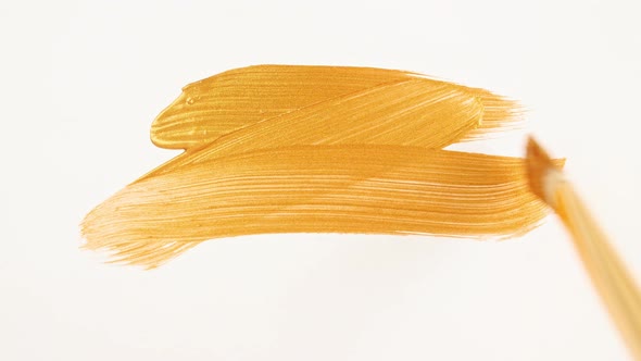 Abstract Brushstrokes of Gold Paint Brush Applied Isolated on a White Background