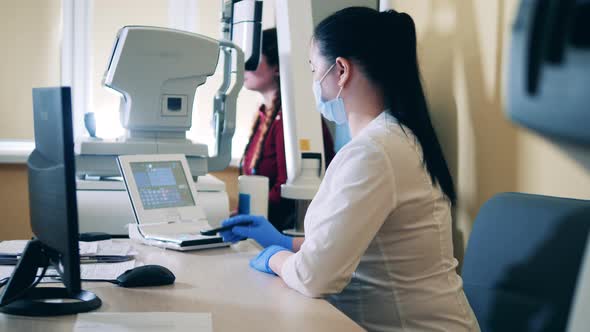 Doctor is Operating a Medical System to Examine Lady's Eyes