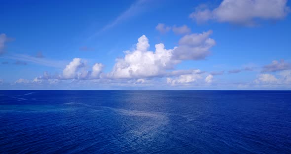 Tropical above travel shot of a white paradise beach and blue sea background in 4K