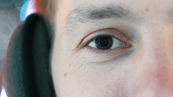 Close-up of Man Eye, in the Pupil the Reflection of Garlands and New Year's Lights.