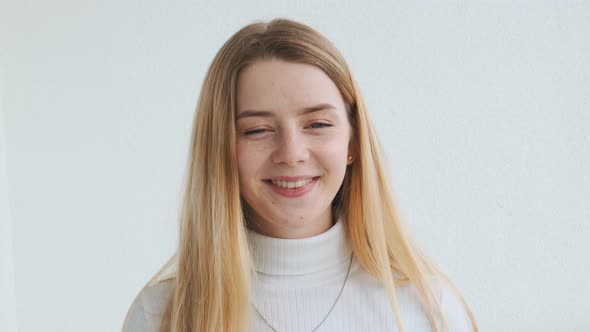 Portrait of a Young Attractive Blonde European Smiling Girl Looking at the Camera