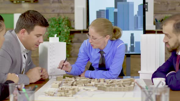 Middle Age Female Architect in a Meeting with His Team in the Conference Room