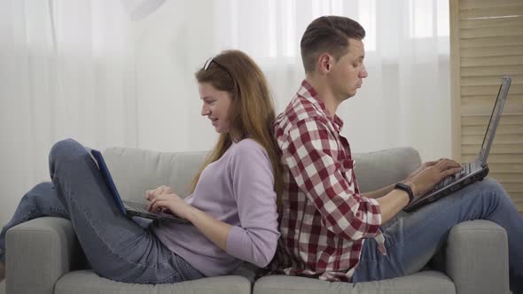 Young Man and Woman Using Social Media and Smiling