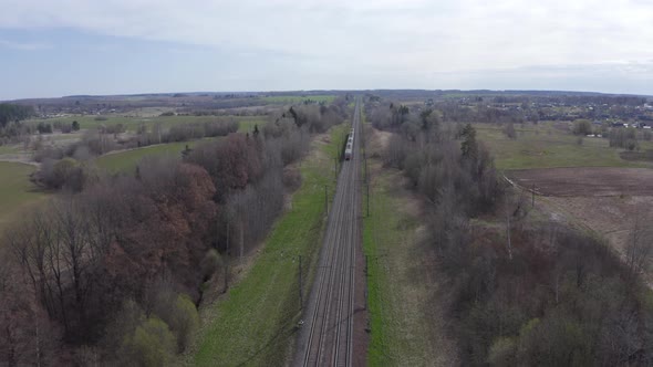 Electric Passenger Train Rides on Rails Among the Fields on a Sunny Spring Day