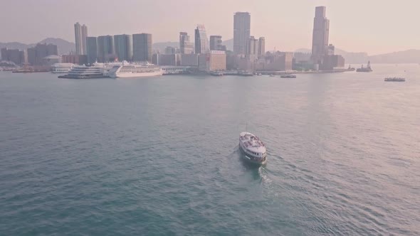 Star ferry from Hong Kong Island to Kowloon at sunrise. Aerial drone view