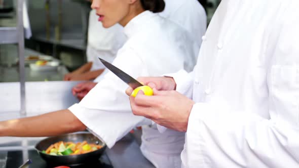 Team of chefs chopping vegetables and preparing food