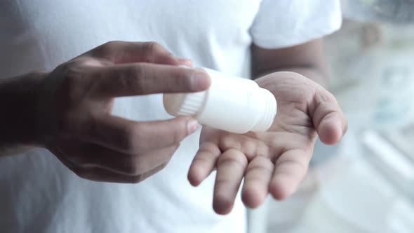 Man's Hand with Medicine Spilled Out of the Pill Container