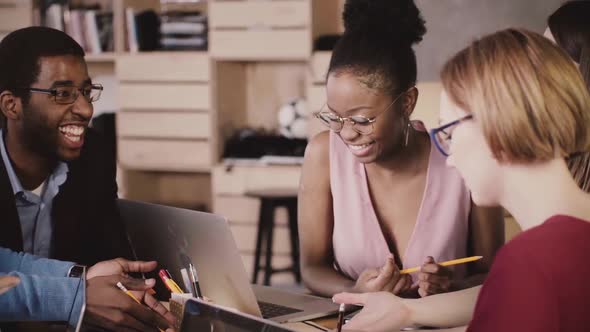 Cheerful African American Female Manager Brainstorming with Happy Multiethnic Colleagues in Modern