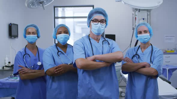 Portrait of diverse female and male surgeons wearing face masks and scrubs in hospital