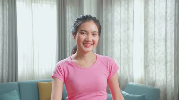 Front View Of Asian Woman Training On Walking Treadmill And Smiling At Home