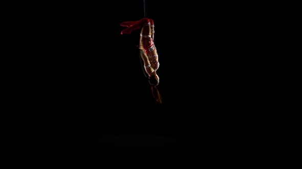 Girl Performs the Acrobatic Elements in the Air Ring. Black Background