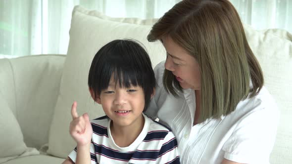 Asian Child And His Mother Talking Together