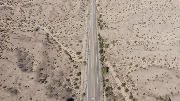 Static aerial view of cars driving along a road in an Arizona desert