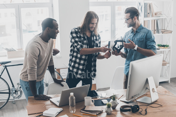 eople working and communicating together while standing in creative office