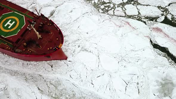 Drone Top Down Epic Red Steel Icebreaker Ship Tanker Breaks Winter Frozen Sea Overcomes