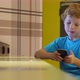 Blonde boy uses smartphone while surfing the internet in cafe - VideoHive Item for Sale