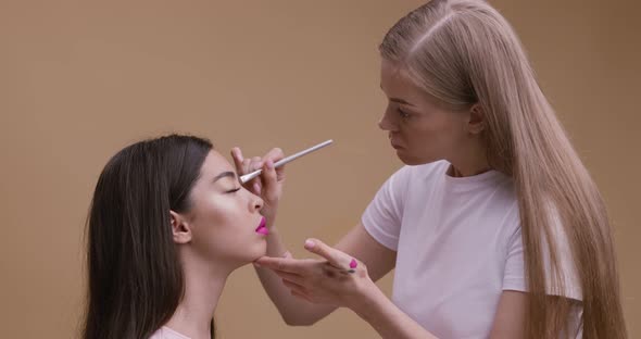 Professional Make Up Artist Making Ceremonial Makeup for Beautiful Asian Lady