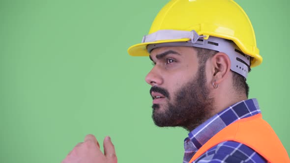 Closeup Profile View of Happy Young Overweight Bearded Indian Man Construction Worker Thinking