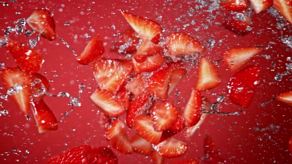 Super Slow Motion Shot of Fresh Strawberries and Water Side Collision on Red Background at 1000Fps.