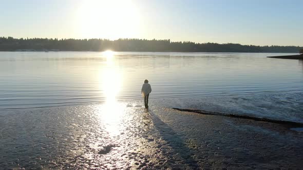 Low level aerial drone flight around woman at sunset on the Puget Sound near Olympia in Washington S