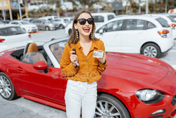 driver’s license and keys near the red cabriolet at the car parking. Concept of a happy buying or renting a car