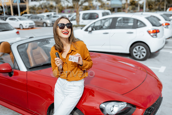 driver’s license and keys near the red cabriolet at the car parking. Concept of a happy buying or renting a car