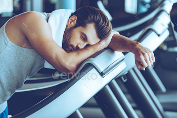 tswear looking exhausted while leaning on treadmill at gym