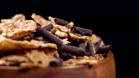 Wheat flakes with chocolate chips in a rustic wooden bowl. Macro shot. Healthy fitness breakfast
