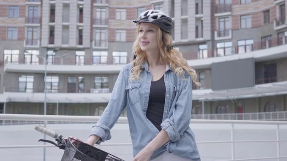 Portrait Pretty Blond Woman in Bike Helmet Standing with Bicycle Against the Background