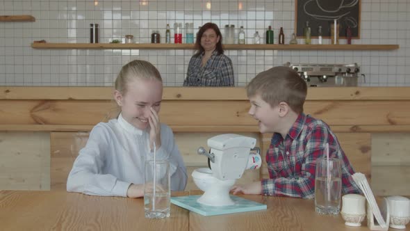 Happy Kids Laughing Playing Toy at Cafeteria Table