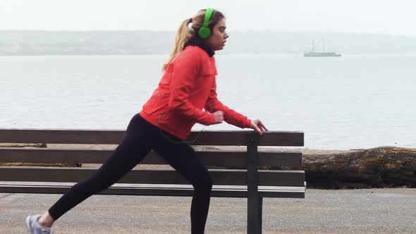 Woman performing stretching exercise at seaside 4k