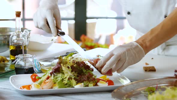 Hands Put Meat on Salad.