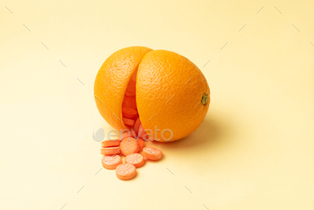 range peel, on a yellow background, vitamin C pills as an alternative to citrus fruits close up.