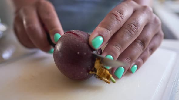 Closeup Passion Fruit with Female Hand Cutting Fruit on Halves