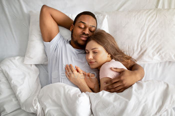 Affectionate interracial couple sleeping in bed and hugging, top view. Love and relationships / Photodune, Misc