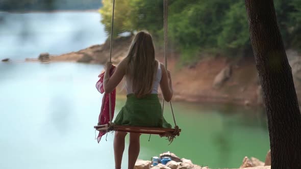 Young Woman Swinging Near Lake Camp Side In Summer