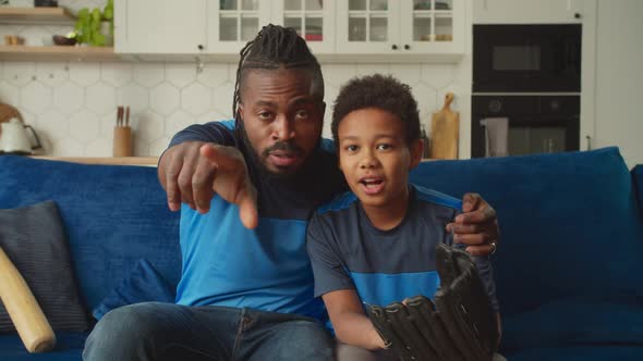 Positive Black Family with Boy Watching Baseball Game on Tv at Home