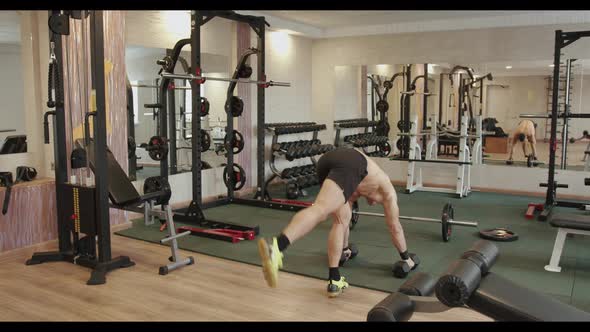 Strong Young Man in Black Sports Shorts Training in the Gym and Doing a Handstand Leaning on Big