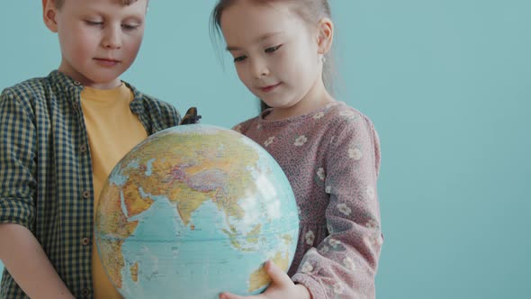 Cute Schoolchildren Posing with World Globe