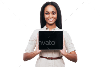 an showing her digital tablet and smiling while standing against white background