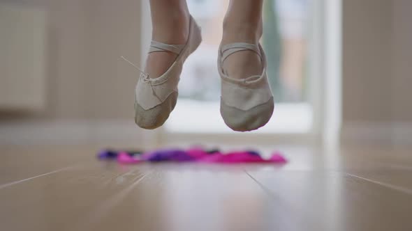 Closeup Feet of Slim Teen Gymnast Jumping Crossing Legs in Slow Motion Indoors