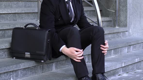 Young Man Sadly Looking Towards Office Center, Upset by Dismissal From Work