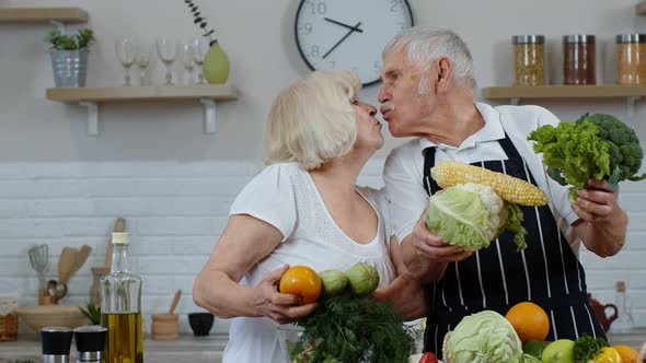 Senior Man and Woman Recommending Eating Raw Vegetable Food. Mature Grandparents Couple in Kitchen