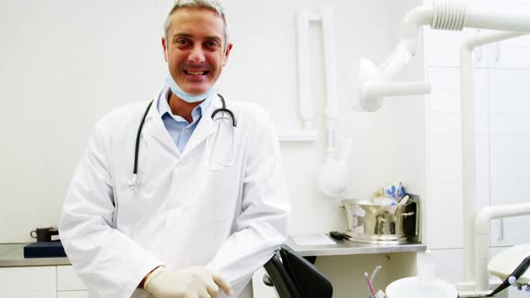 Smiling dentist standing in dental clinic