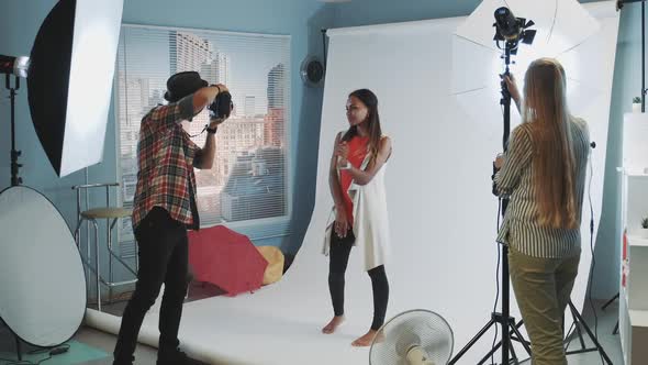 Beautiful African Model Posing for Photo Shoot While Assistant Adjusting the Lighting