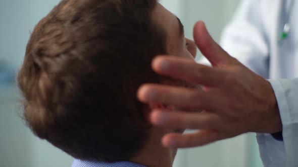 Closeup of Unrecognizable Male Doctor Touching Lymph Nodes on Neck and Massaging Temples to Sick