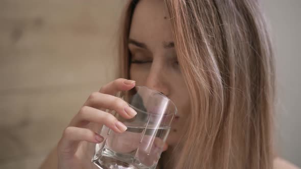 Attractive Woman Taking Supplements Pills and Drink a Glass of Water